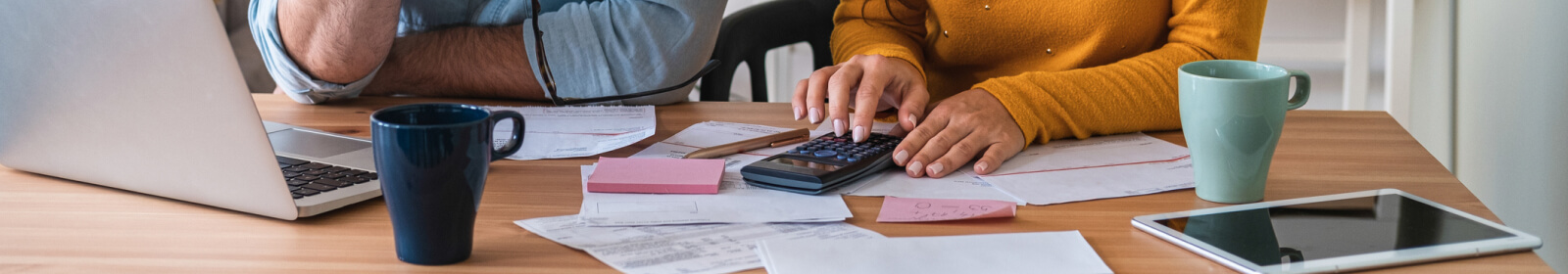 Two people's hands using a calculator