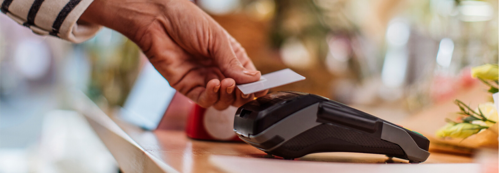 Close up of a person's hands using a credit card reader