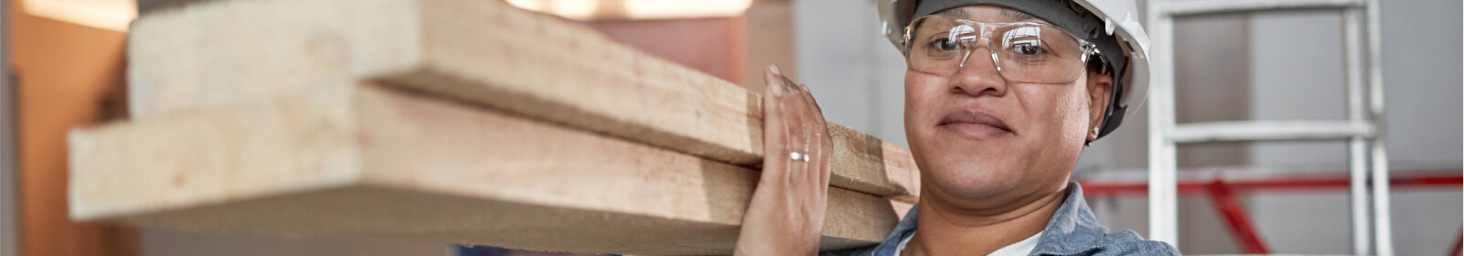 Woman carrying large wooden planks