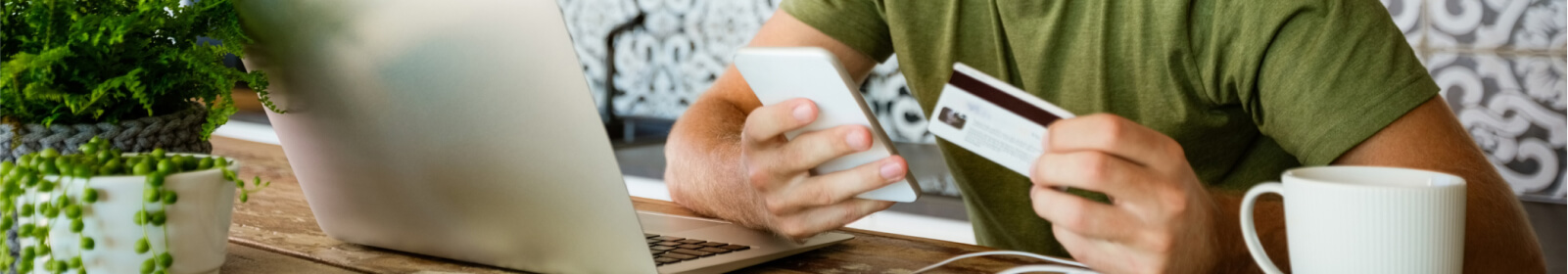 Close up of a person's hands holding a smartphone and a credit card